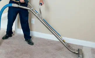 Professional operating a liquid removal machine on a carpeted floor in Santa Ana, CA